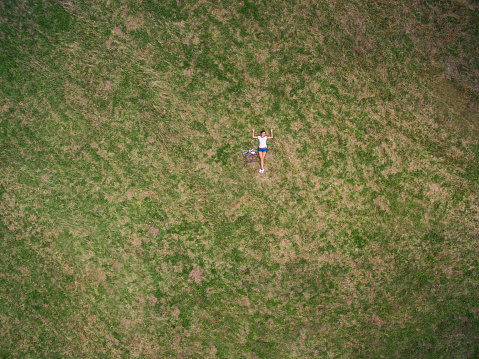 Young female lying on the ground in nature ,high angle view,directly above