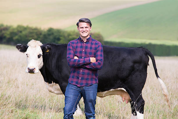 istock Portrait Of Dairy Farmer In Field With Cattle 610560378