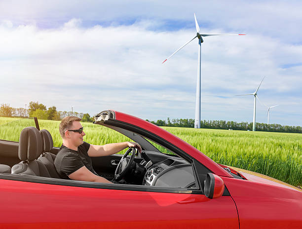 istock Happy young smiling man driving a new car. 610560954