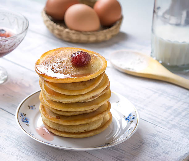 istock Pancakes with strawberry jam, milk and eggs 610563710