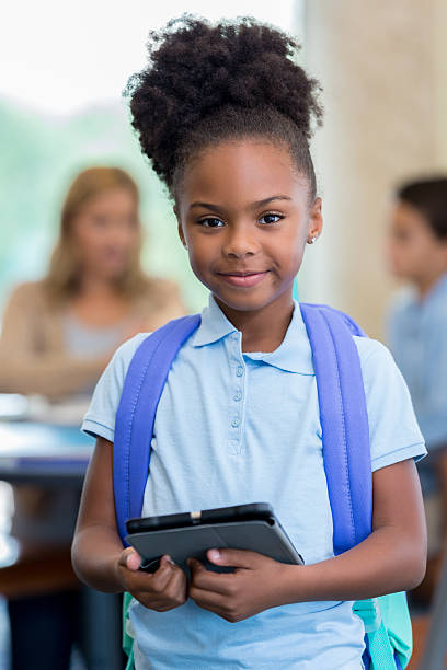 istock Pretty African American elementary schoolgirl with tablet before school 610564366
