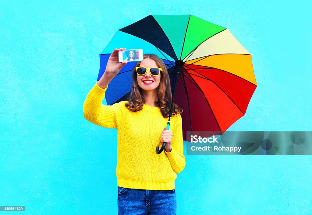 Frau mit bunten Regenschirm nimmt Herbst-Selbstporträt auf dem Smartphone - Lizenzfrei Bewegungsaktivität Stock-Foto