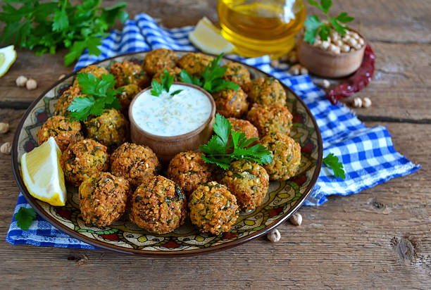 Falafel plate with vegetables salad and sauce.