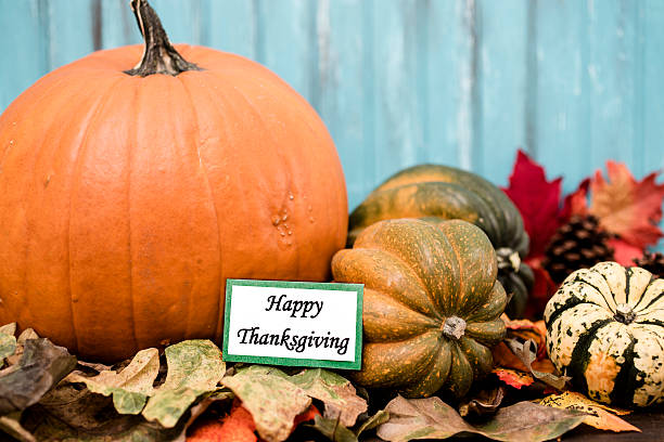 istock Happy Thanksgiving!  Autumn centerpiece with orange pumpkin, leaf decorations. 610568254