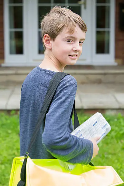 Photo of Portrait Of Teenage Boy Delivering Newspaper To House
