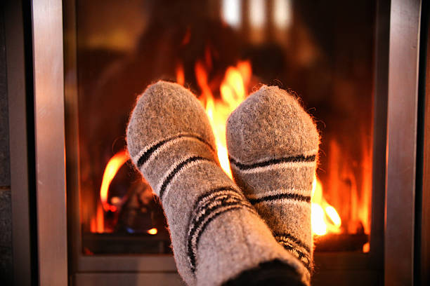 istock Feet in wool socks warming at the fireplace 610571522