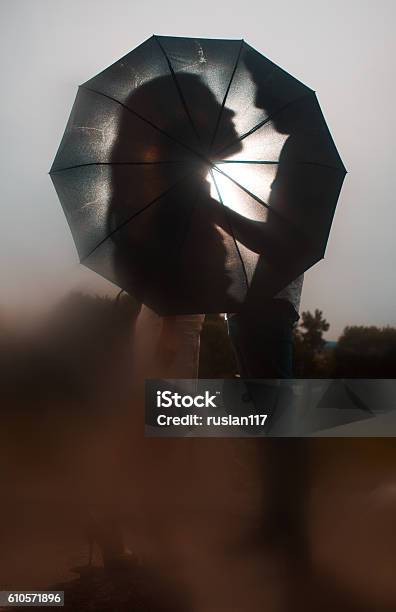 Love In The Rain Silhouette Of Kissing Couple Under Umbrella Stock Photo - Download Image Now