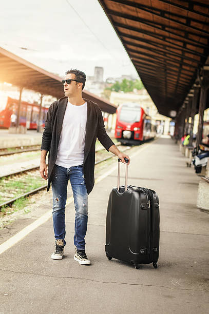 istock Handsome man with suitcase posing on the railway station 610572126