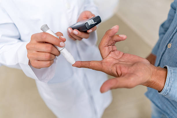 hombre comprobando el nivel de azúcar con glucómetro - blood sugar test fotografías e imágenes de stock