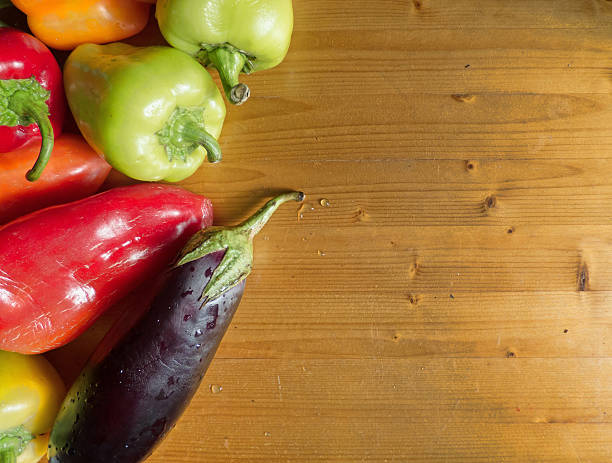 istock Various bell peppers and eggplant on wooden background 610574084