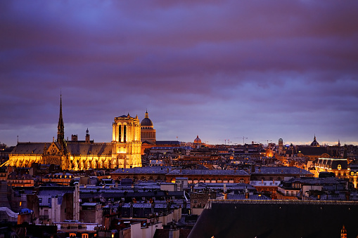 Dramatic view of Paris roofs (with the Cathedral of Notre Dame de Paris) in dusk