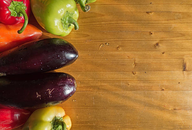 istock Various bell peppers and eggplant on wooden background 610574642