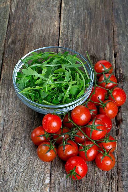 istock fresh rucola and cherry tomatoes on wooden surface 610575614