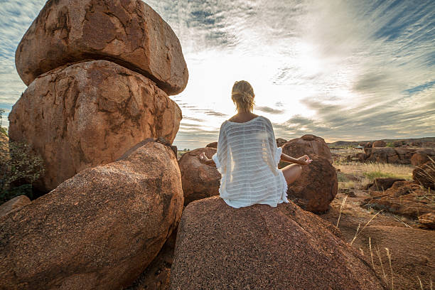 istock Caucasian female on spheric boulder exercises yoga 610576498