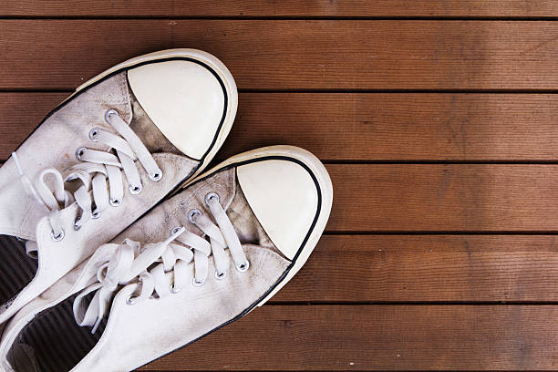 istock Old canvas shoes on a wooden floor 610577328