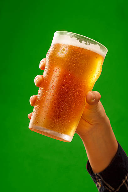 Cheers   Ice cold beer    Hand with beer glass making toast stock photo