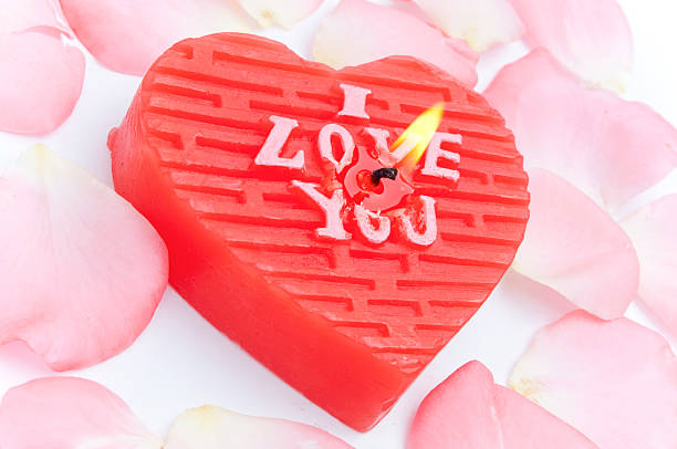 istock Heart shape candle and rose petals 610579224