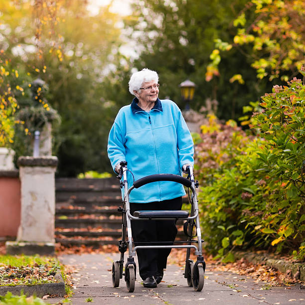 istock Adorable senior lady with a walker in autumn park 610580700
