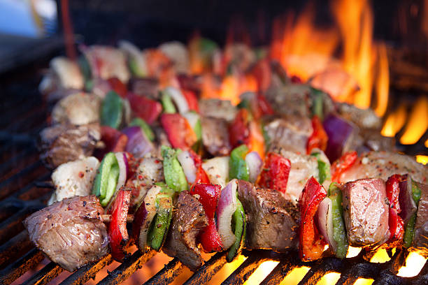 kebabs de carne em uma churrasqueira de fogo com chamas - barbecue grill broiling barbecue vegetable - fotografias e filmes do acervo