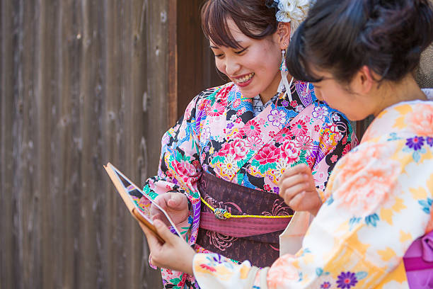 istock Japanese Women in Traditional Kimonos Using Modern Computer Technology 610582616