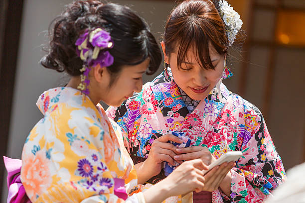 istock Japanese Women in Traditional Kimonos Using Mobile Smart Phone 610582630