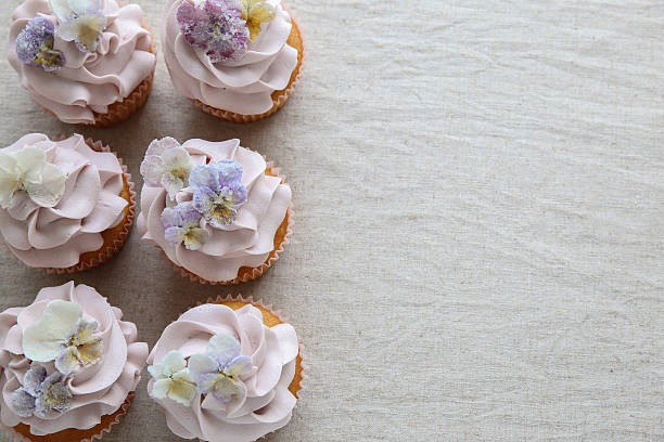 istock Purple cupcakes with sugared edible flowers copy space backgroun 610584172