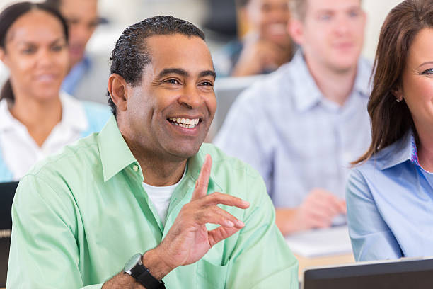 istock Mature African American businessman asks question during conference 610647644