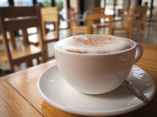 istock Cappuccino coffee in white cup on wooden table in coffee 610648008
