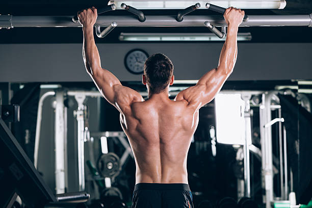 istock Athlete muscular fitness male model pulling up on horizontal bar 610648202
