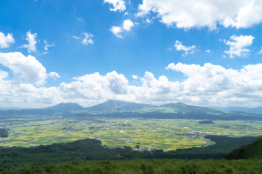 The view of Aso mountain. There is Aso mountain, rice field, town, forest and grasses in Japan.