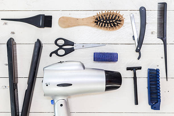 istock Hairdressing tools on white wooden table 610651948
