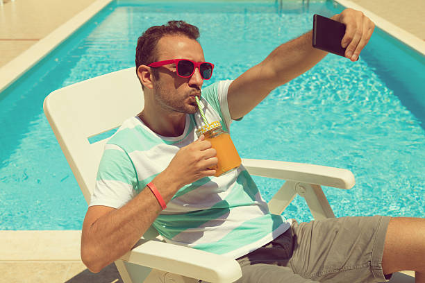istock Man on the swimming pool taking a selfie. 610654788