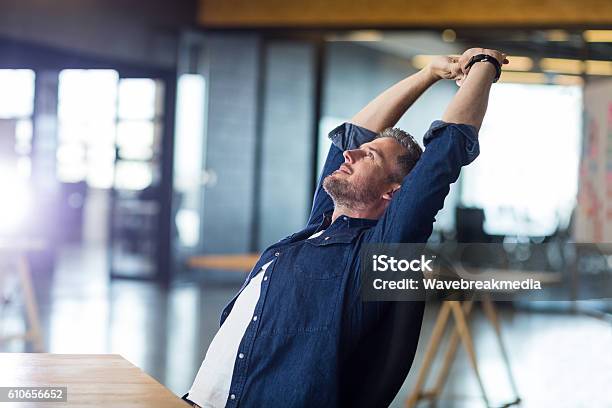 Relaxed Man Sitting In Office Stock Photo - Download Image Now - Adult, Business, Business Finance and Industry