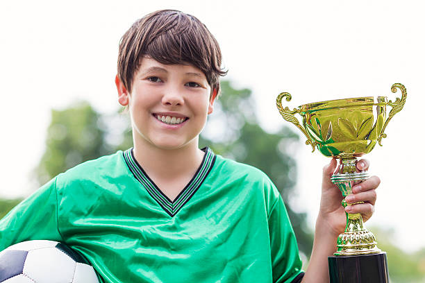 istock Excited soccer champion with trophy 610657020