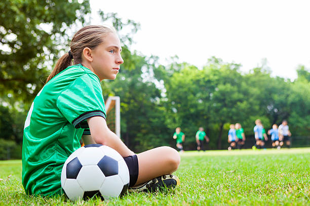 odblaskowy piłkarz siedzi na uboczu podczas gry - match sport sport outdoors teenagers only zdjęcia i obrazy z banku zdjęć