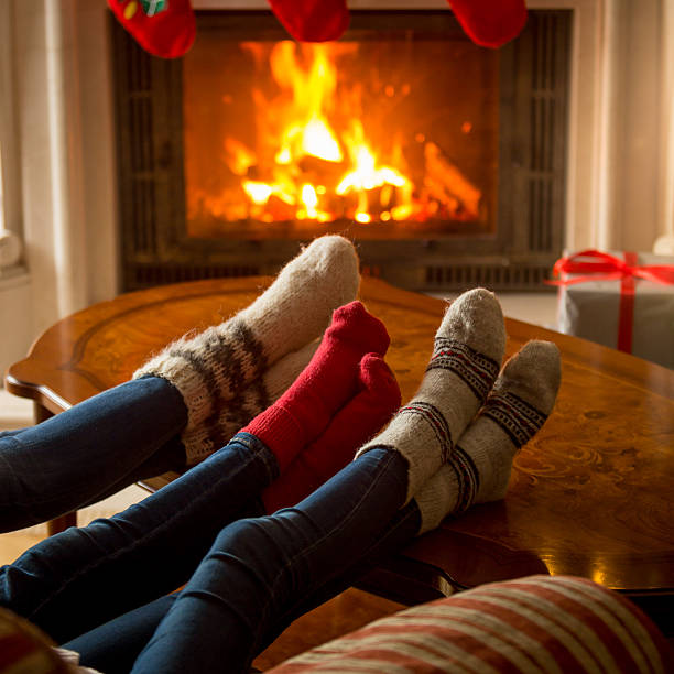 istock Family in knitted woolen socks warming at burning fireplace 610660644