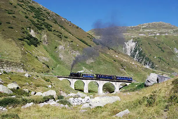 Steam train of the Dampfbahn Furka-Bergstrecke (Furka Cogwheel Steam Railway) driving over the Steinstafel viaduct on its way from Realp in Canton Uri to Oberwald in Canton Valais.