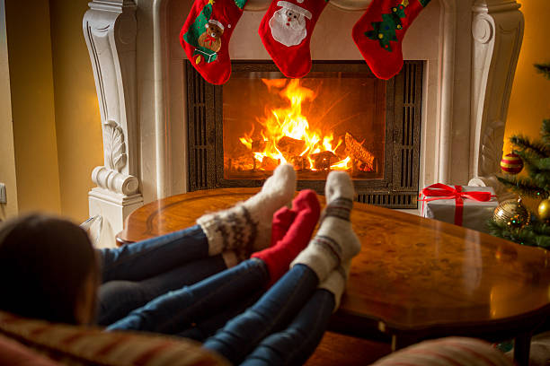 istock Family in knitted socks warming at fireplace decorated for Christmas 610660954