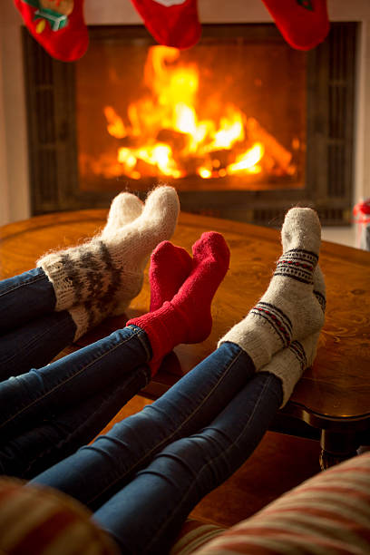 istock Family in socks warming at burning fireplace at house 610661152