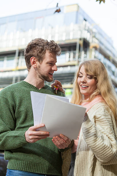 istock Couple with blueprint project keys on construction site 610661260