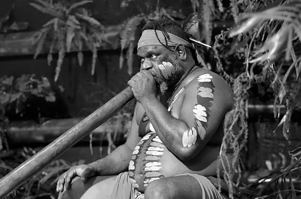 Portrait of one   Yirrganydji Aboriginal man play Aboriginal music on didgeridoo, instrument during Aboriginal culture show in Queensland, Australia.(BW)