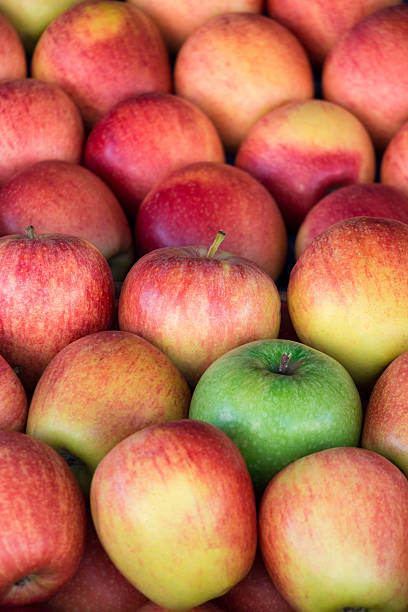 istock Unique. Green apple among a group of red apples. 610663226