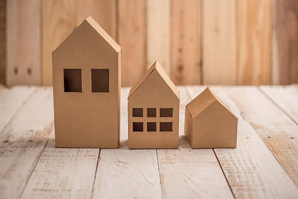 model of cardboard house on wooden floor model of cardboard house on wooden floor and background. house building, loan, real estate or buying a new home concept. cardboard house stock pictures, royalty-free photos & images