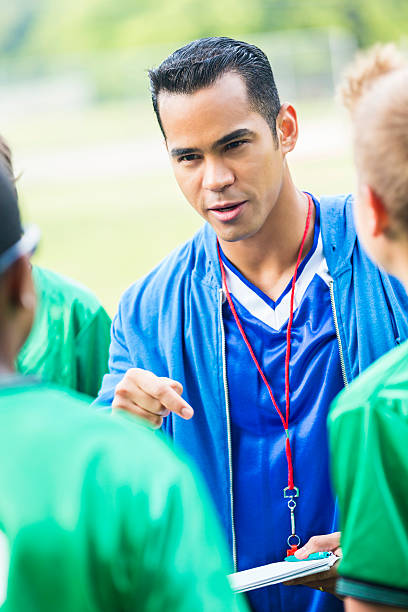 istock Intense Hispanic soccer coach gives players pep talk 610665122