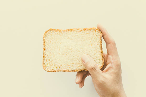 istock Hands hold a slice of bread on white background 610667434