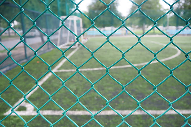 istock Wire mesh fence in soccer field. 610672778