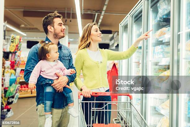 Mother And Father With Their Baby Daughter Grocery Shopping Stock Photo - Download Image Now