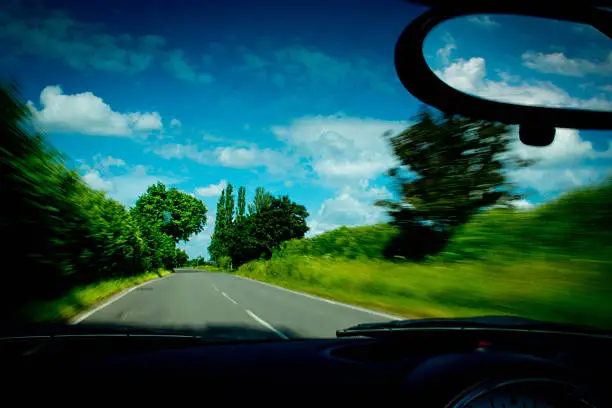 A BMW Mini Cooper S convertible rear view mirror with a background of the beautiful Cambridgeshire countryside.