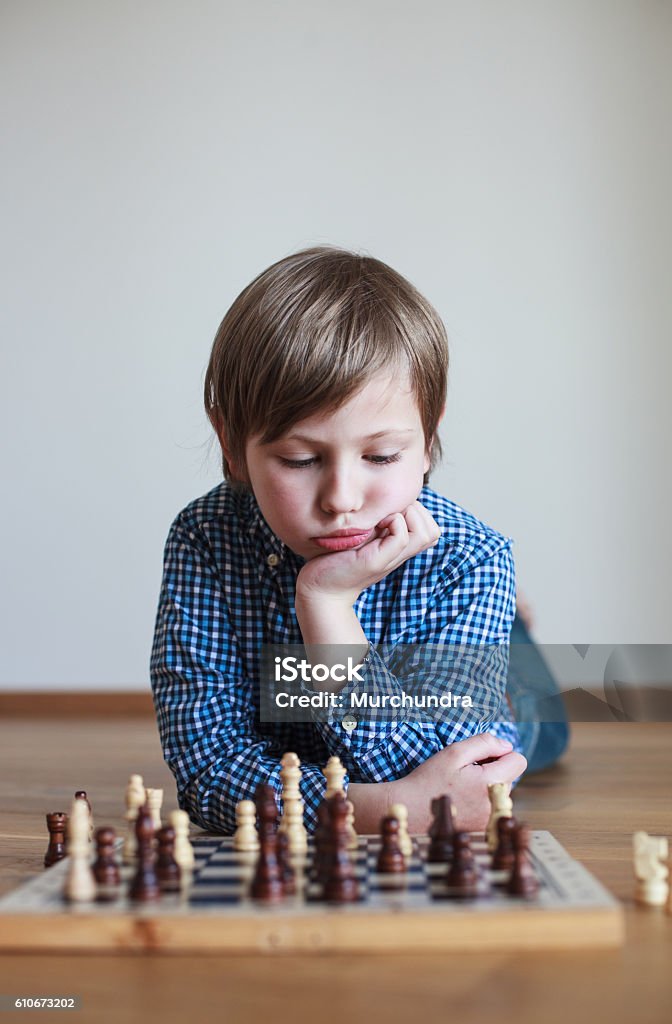 Cute boy playing chess Boys Stock Photo