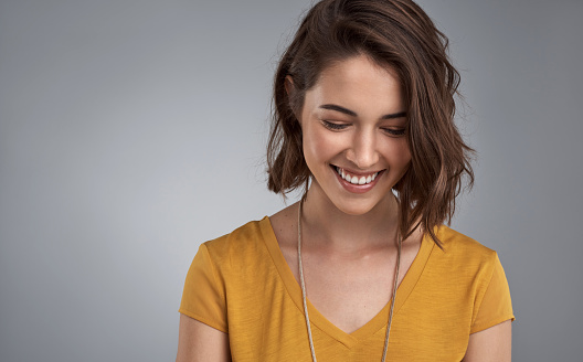 Studio shot of an attractive young woman posing against a gray background